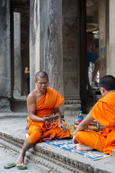 Cambodian monks sitting on stairs at Angkor Wat temple, Cambodia — Stock Photo, Image