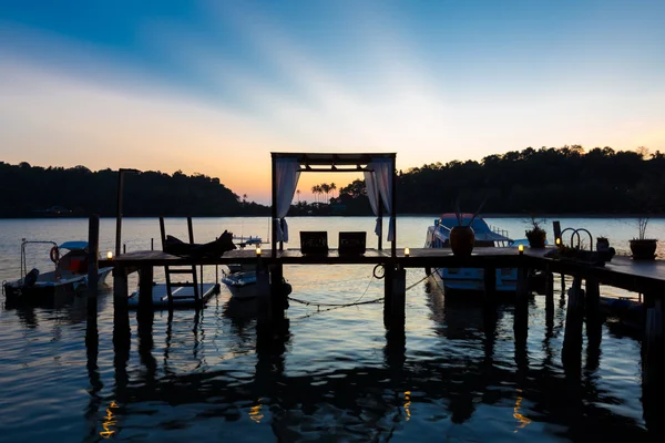 タイ木製の桟橋が湖に沈む夕日でパーゴラ ラウンジをテラスします。 — ストック写真
