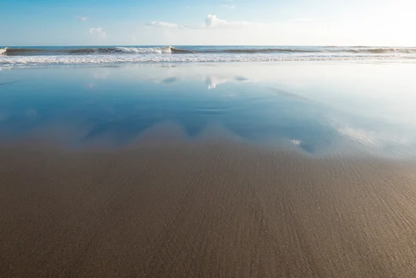 Nubes reflejadas en las arenas húmedas de Balian Beach, Bali, Indones —  Fotos de Stock