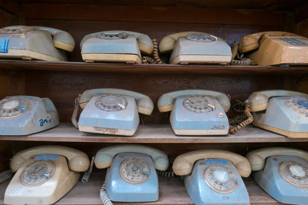 Wooden shelves with old vintage used blue phones. Indonesia — Stock Photo, Image