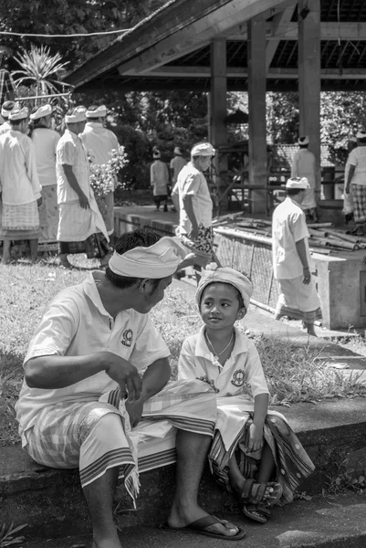 Young Balinese son and hist father during religious ceremony in — 스톡 사진