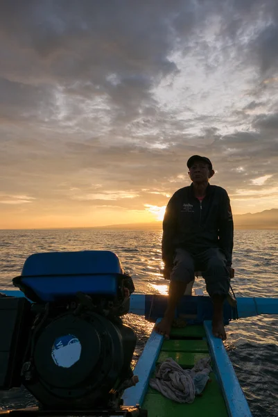 Fisher man, traditionele houten boot en uitzicht op de Oceaan tijdens sunris — Stockfoto