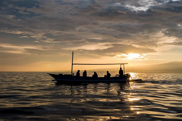 Fantastische zonsopgang met silhouet van mensen in kleine boot in Lovin — Stockfoto