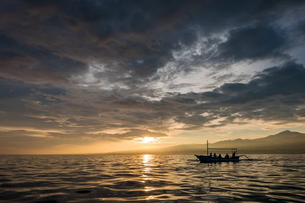 Amazing sunrise with silhouette of people in small boat in Lovin — Stock Photo, Image