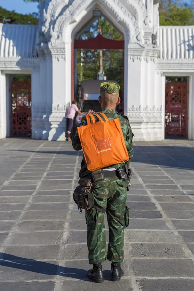 Thai fiatal katonai állva narancssárga bevásárlótáska Bangkokban — Stock Fotó