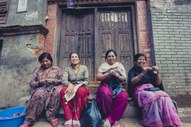 Gülümseyen ve sokakta çalışan Bhaktapur kadınlar. Nepal