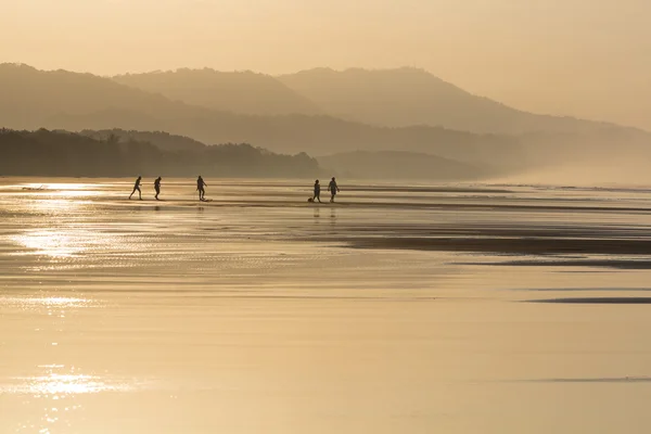 Siluetas de personas caminando por la playa —  Fotos de Stock