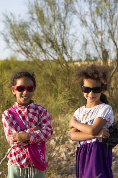 Zwei junge marokkanische Schwestern posieren mit Sonnenbrille und Naturbac — Stockfoto