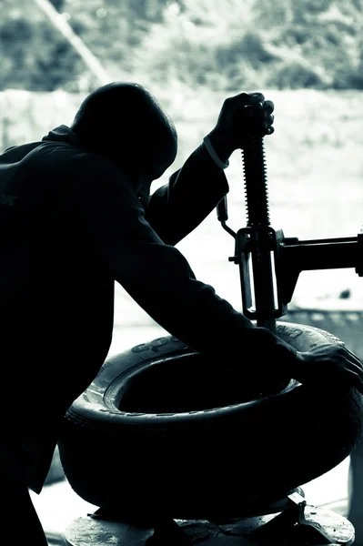 Monteur op werk bevestiging banden in een garage in Namibië. Duo toned — Stockfoto