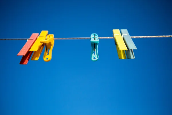 Gekleurde wasknijpers met blauwe lucht — Stockfoto