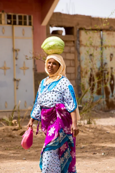 Moroccan woman carrying a watermelon on her head — Stock Photo, Image