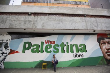 Bir sandalyede oturuyor ve boyama Chavez ve Viva Palestina dostum