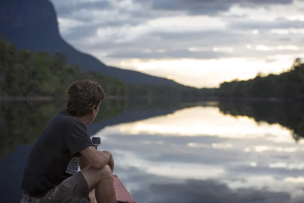 Homme regardant le coucher du soleil sur la montagne Auyantepui dans le Canaima — Photo
