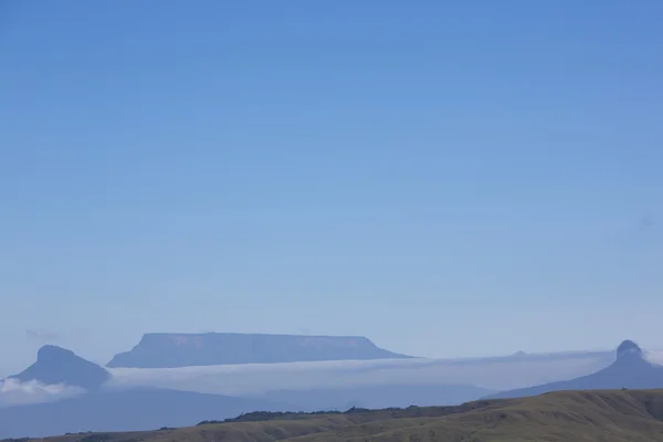 Nubes blancas sobre las montañas con cielo azul claro — Foto de Stock