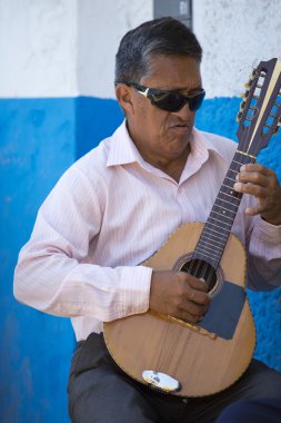 Peruvian blind musician playing guitar outside, Trujillo