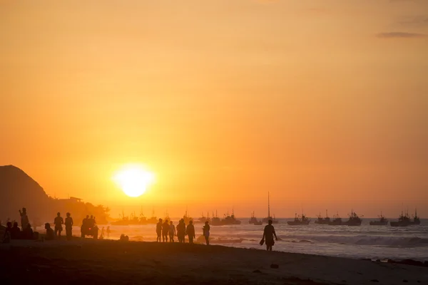 Gente caminando por la playa de Mancora durante el atardecer naranja —  Fotos de Stock