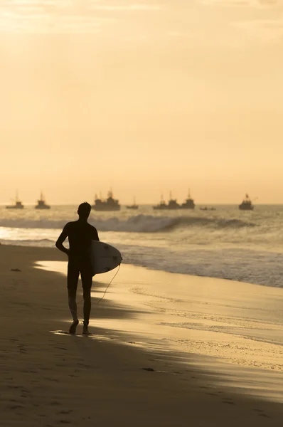 Silhouette de surfeur marchant sur la plage lors d'un coucher de soleil — Photo