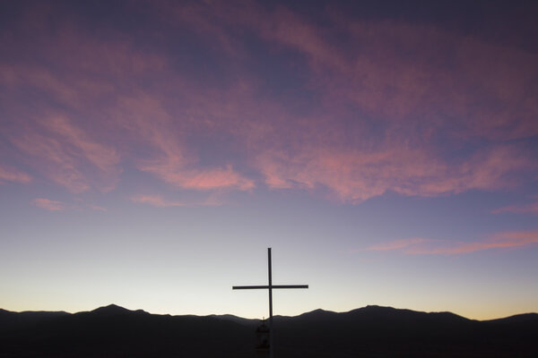 Silhouette of catholic cross in the mountain at sunset, Bolivia