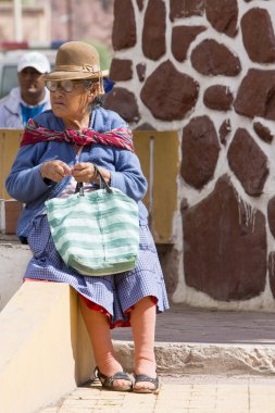 Outdoors Bolivian senior women sitting on a bench, Tupiza