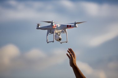 Beyaz dron parlak mavi gökyüzü ile el kedi hazır hovering