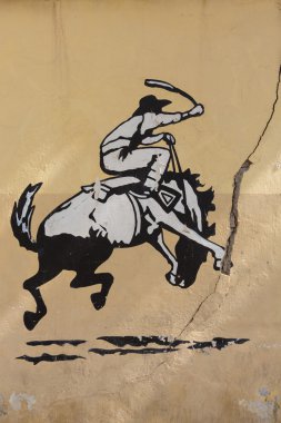 Graffiti of rodeo, man riding horse. Old Wall, Argentina clipart