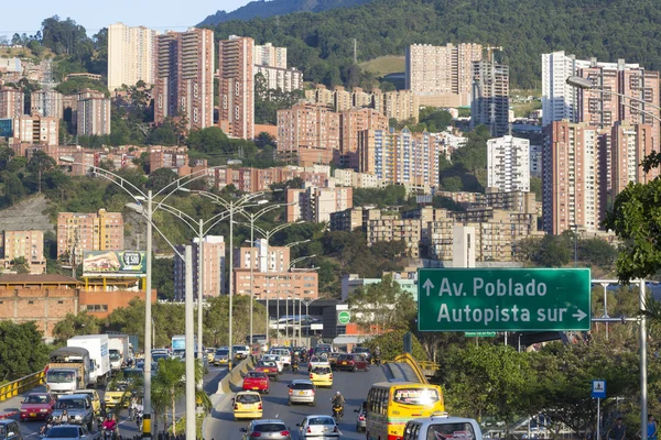 Cityscape and traffic on the road with road sign to Poblado, Med — Stock Photo, Image