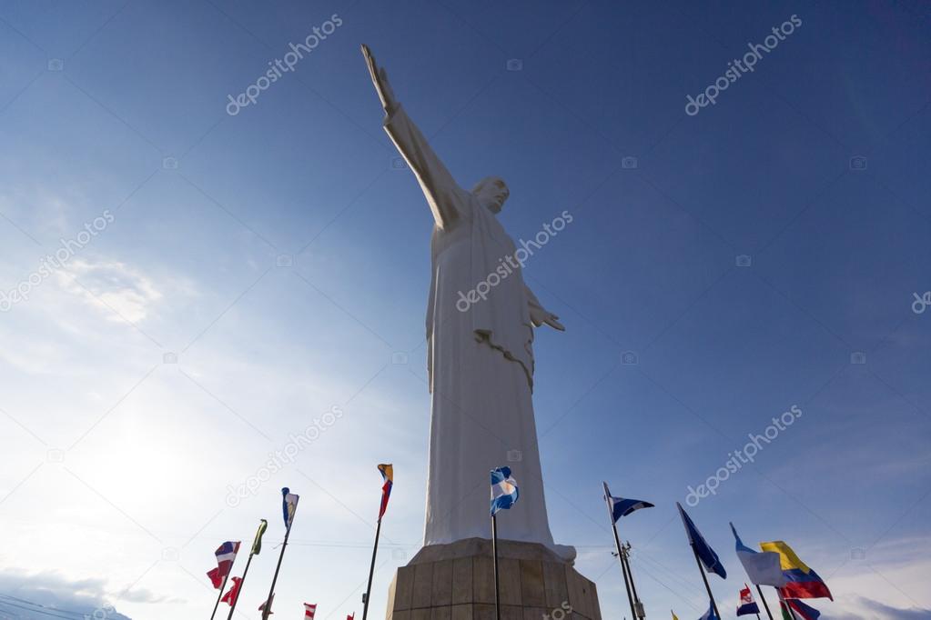 Cristo del Rey statue of Cali with world flags and blue sky, Col