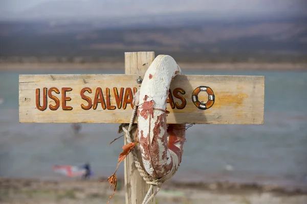 Life buoy and sign dangerous to swim, Lake of Wind, Argentina — Stock Photo, Image