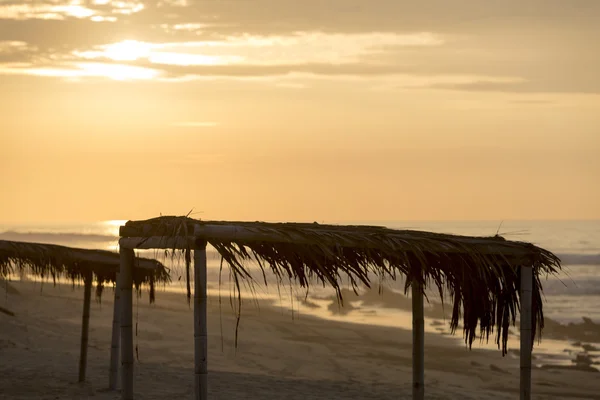 Sunset on Punta Sal beach with wooden shelters, Peru — Stock Photo, Image