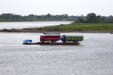 trucks on a barge pulled by a motorboat in Rurrenabaque, Bolivia clipart