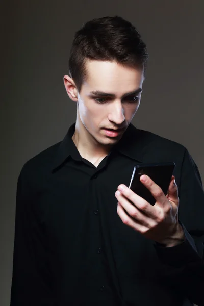Jeune homme debout avec téléphone portable — Photo