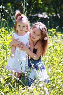 Little sisters çayır üzerinde gülümseyen
