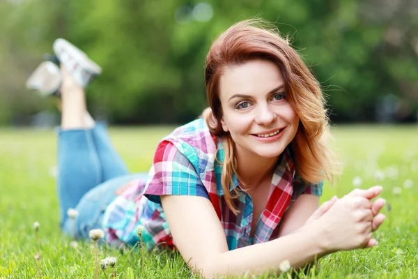 Vrouw opleggen op het gras — Stockfoto