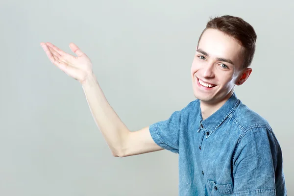 Joven casual hombre apuntando lejos — Foto de Stock