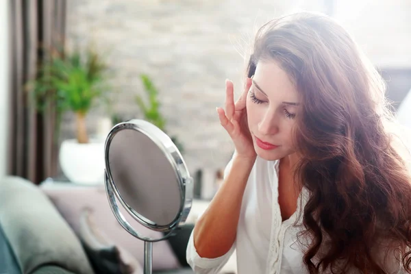 Woman looking in the mirror — Stock Photo, Image