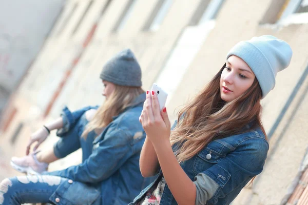 Chica hipster mirando el teléfono inteligente — Foto de Stock