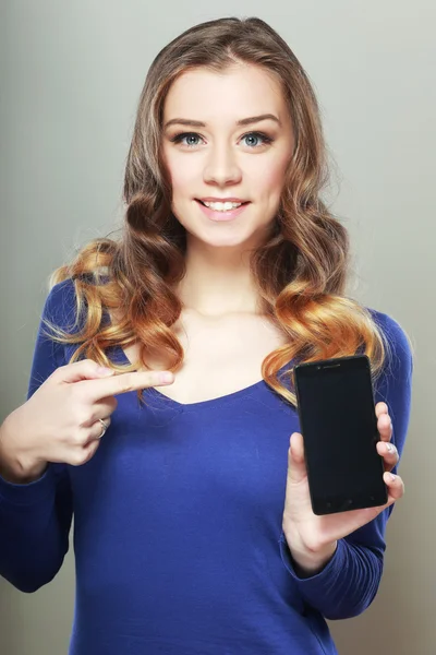 Mujer muestra una mirada a un teléfono inteligente —  Fotos de Stock
