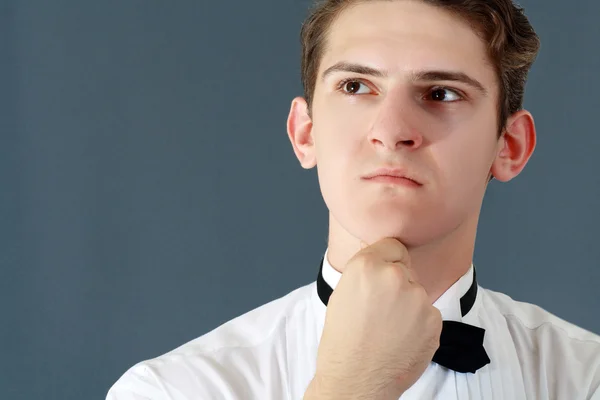 Man in a shirt and bow tie thinking — Stock Photo, Image