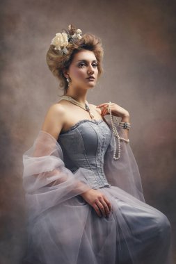 Tuhaf bir prenses ya da kontes gibi giyinmiş bir kızın portresi.