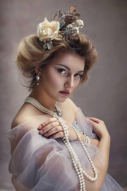 İnci takılı, romantik elbiseler giyen çekici genç aristokrat kadının portresi.