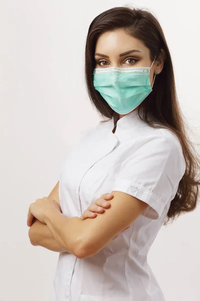 美しい女性医師がマスクをつけて腕を折り — ストック写真