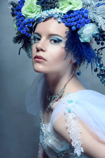 青いドレスと花冠を身に着けているファンタジーキャラクターのような美しい女性のドレッシングの屋内肖像画 — ストック写真