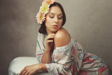 İpek bornozla poz veren genç bir kadının güzel resmine bakın.