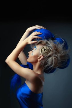 Yaratıcı makyajlı ve mavi saçlı kadın modelin yaratıcı portresi.