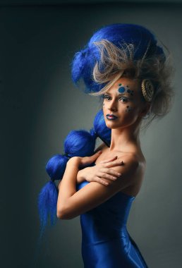 Yaratıcı makyajlı ve mavi saçlı kadın modelin yaratıcı portresi.