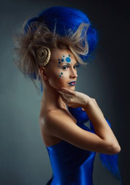 Yaratıcı makyajlı ve mavi saçlı güzel bir kadın.