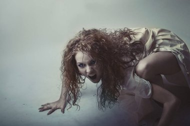 Korkunç korkmuş kadın karanlıktan sürünerek çıkıyor.