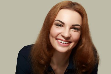 Arka planda gülümseyen, gülümseyen genç bir kadının yakın portresi