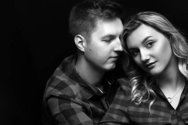 Çift birbirine yakın rahatlıyor, seçilmiş kıyafetler giyiyor, romantik konsept siyah-beyaz.