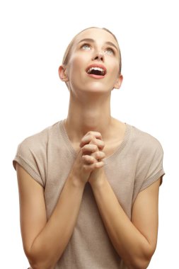 Yüzünde hoş bir gülümsemeyle beyaz arka planda yalnız bir şekilde dua eden kadın.